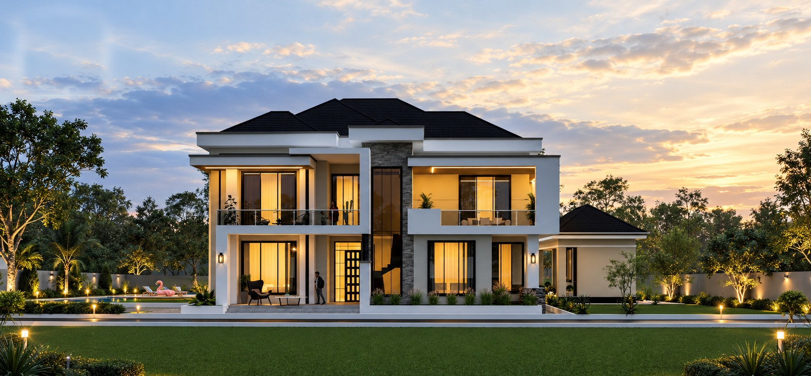 Contemporary two-storey villa at dusk with warm golden interior lighting, stone feature walls, dark roof and a lit garden with pool terrace